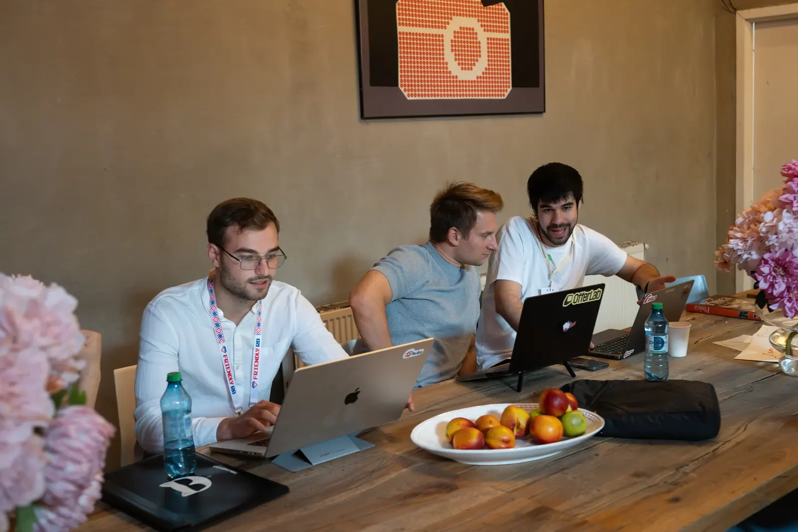 Attendees coding on laptops at a table in the SupeRails Hack Space at Friendly.rb 2025